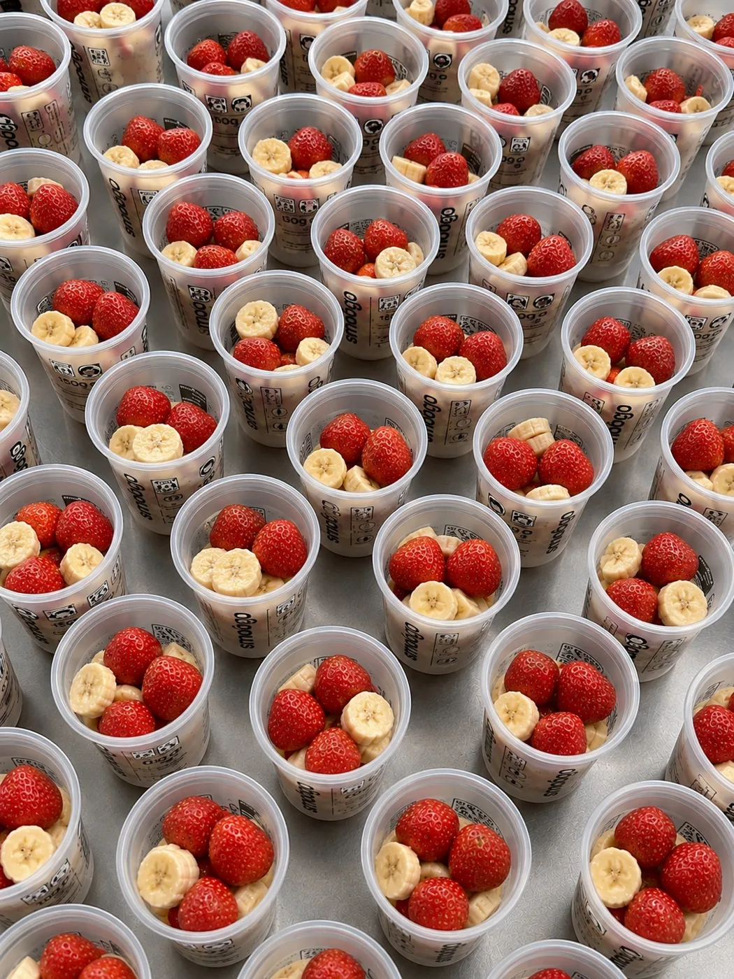 Vasos SMOOGO con porciones de fruta congelada en la máquina